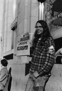 Rick "Lou Lemming" James selling the radical rag Georgia Straight, corner of Yates and Douglas, Victoria, B.C., circa 1969